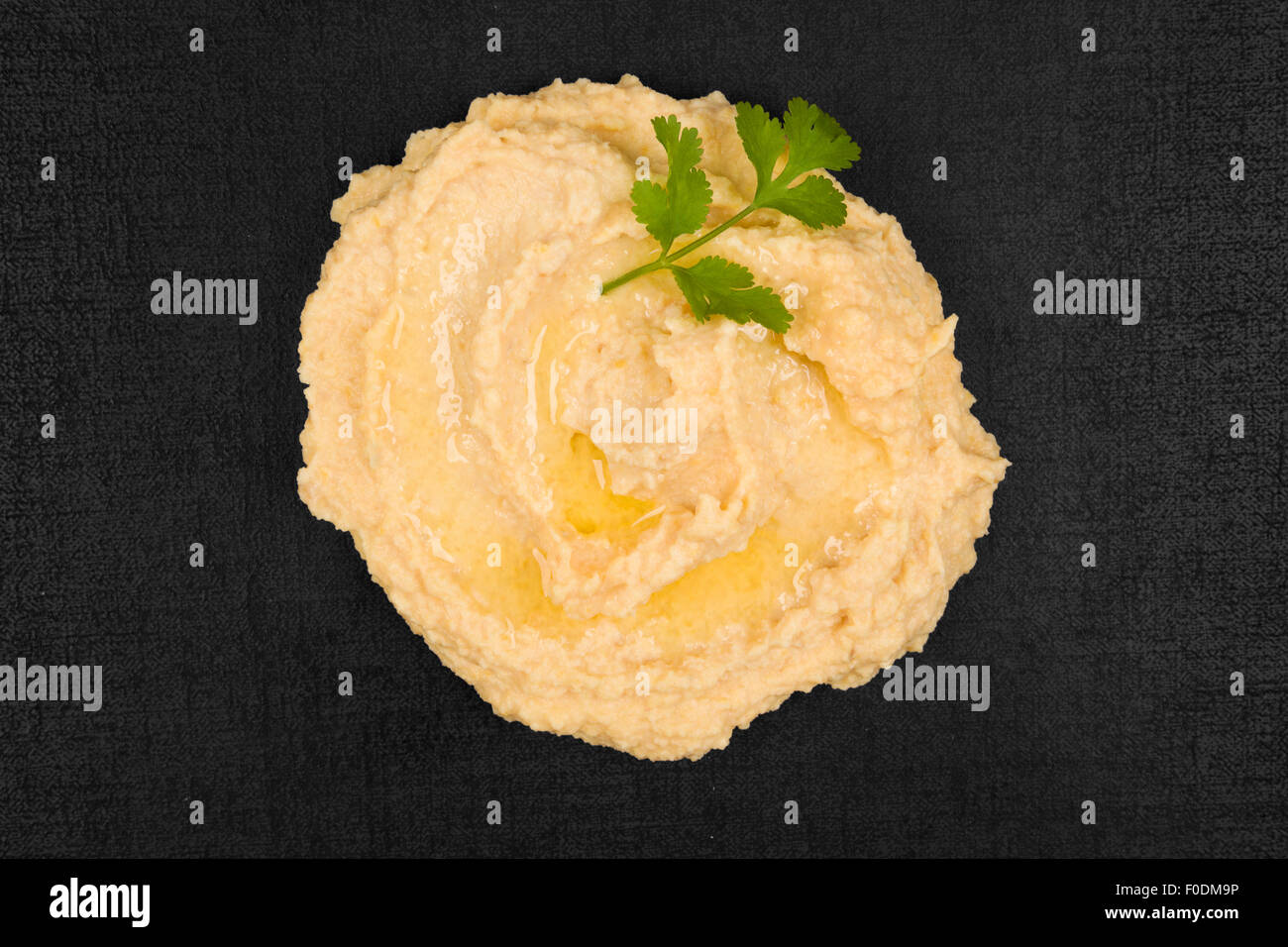 Hummus mit Petersilie Kraut auf schwarzem Hintergrund, Ansicht von oben. Kulinarischen traditionellen östlichen Essen. Stockfoto