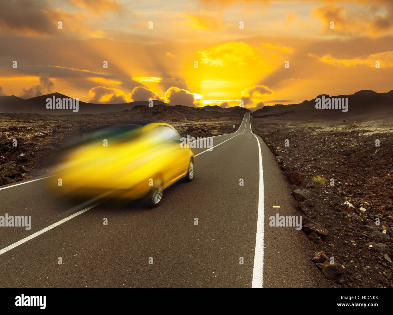 gelbe Sonnenuntergang über schnelles Auto und Asphaltstraße, Kanarischen Insel Lanzarote Stockfoto
