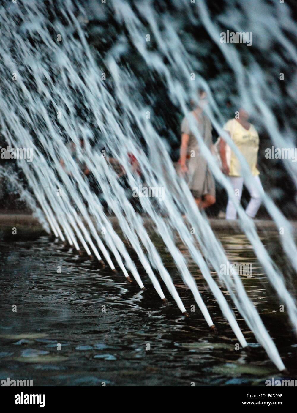 Linie von Wasserdüsen in einem Brunnen, Berlin. Zwei Frauen zu Fuß durch. Stockfoto