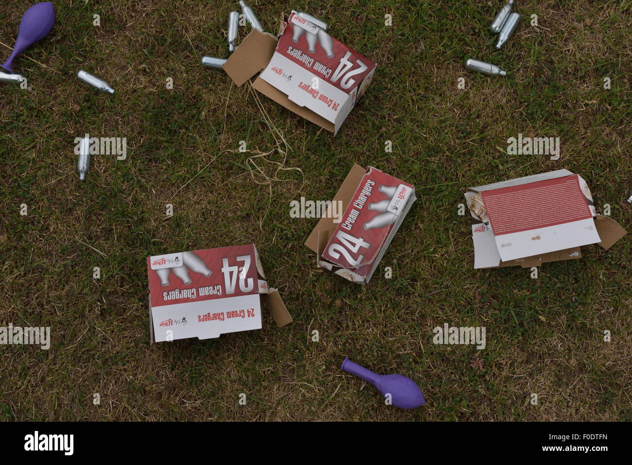 Metall Lachgas-Kanister und Lager Dosen littering einen lokalen Kinderpark verworfen. Stockfoto