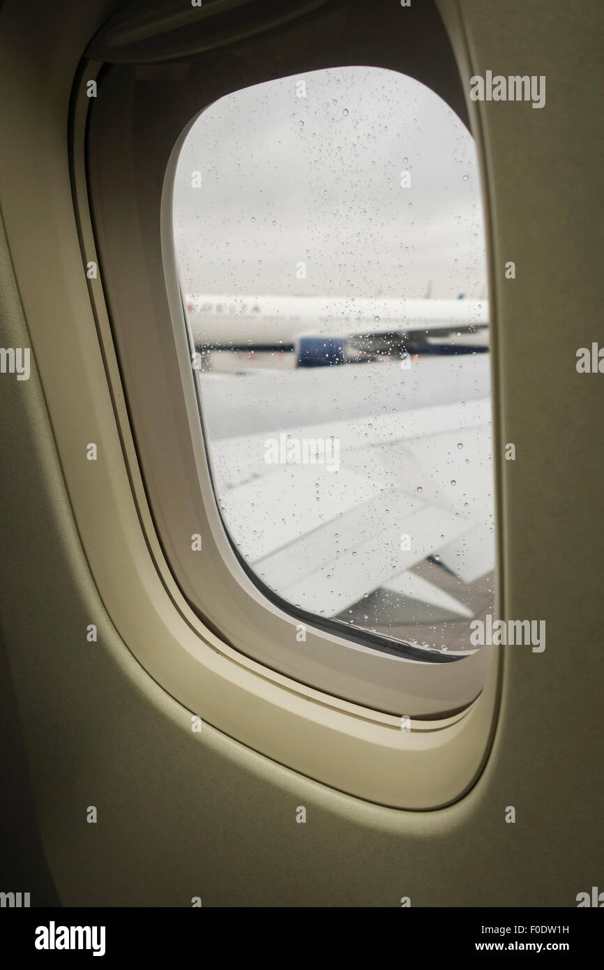 Regentropfen auf Flugzeug Fenster Newark Flughafen, Flügel aus dem Fokus, USA. USA. Stockfoto