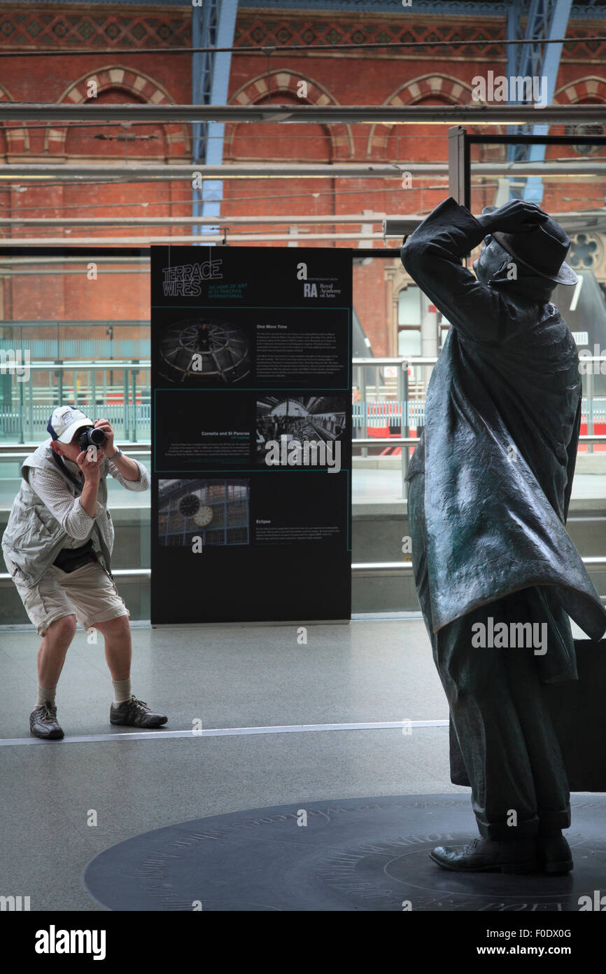 Ein Tourist Fotos John Betjeman Statue in St Pancras station London Stockfoto