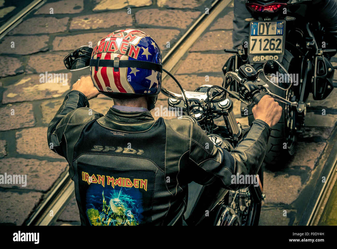 Motorradfahrer tragen Leder mit Iron Maiden gedruckt auf der Rückseite und einen Helm mit der amerikanischen Flagge drauf. Stockfoto