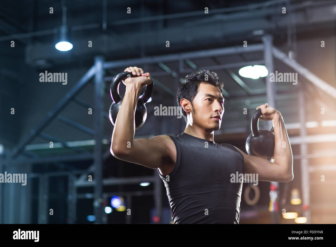 Junger Mann Training mit Kettlebells in Crossfit gym Stockfoto