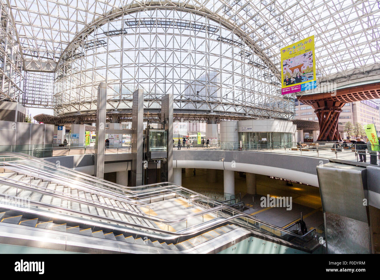 Japan, Kanazawa. JR-Bahnhof, Interieur des Außen Glasatrium, Motenashi (Willkommen) Dome, mit Fahrtreppen zu niedrigeren Niveau Shopping Bereich. Nacht. Stockfoto