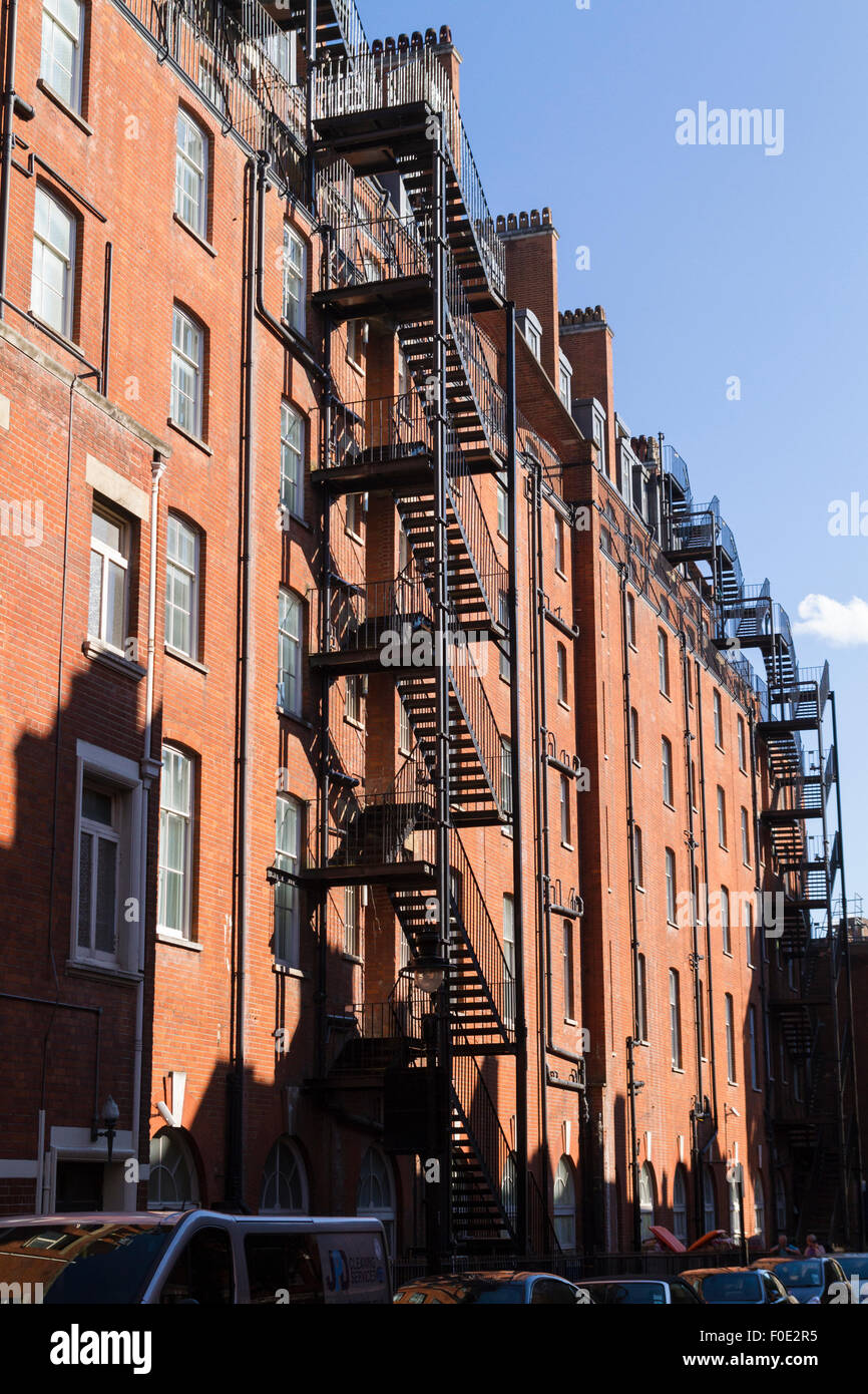 Feuerleitern auf einem roten Backsteingebäude in London Stockfoto