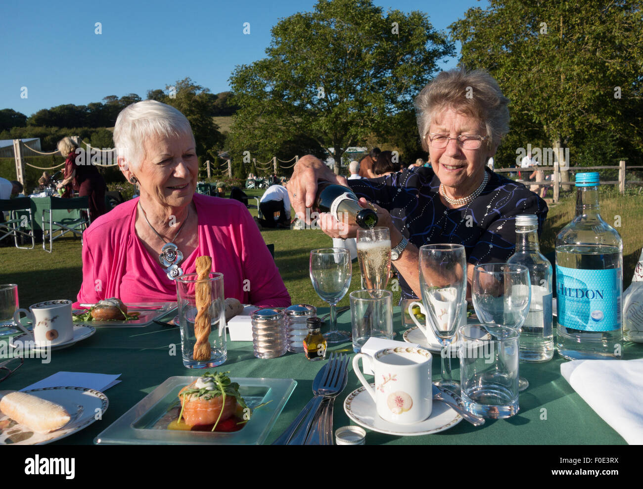 Zwei leitende ältere Frauen Spaß mit einem Champagner-Picknick, Glyndebourne, Sussex England UK Stockfoto