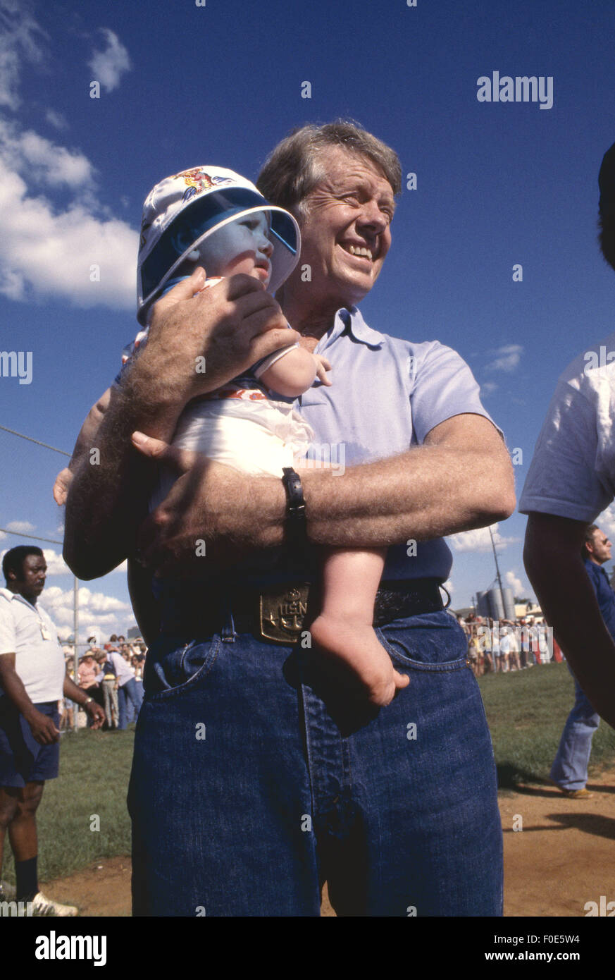 Plains, Georgia, USA. 2. Januar 1977. Jimmy Carter hält das Baby einer Freundin bei einem Softballspiel in Plains, Georgia. © Ken Hawkins/ZUMA Draht/Alamy Live-Nachrichten Stockfoto