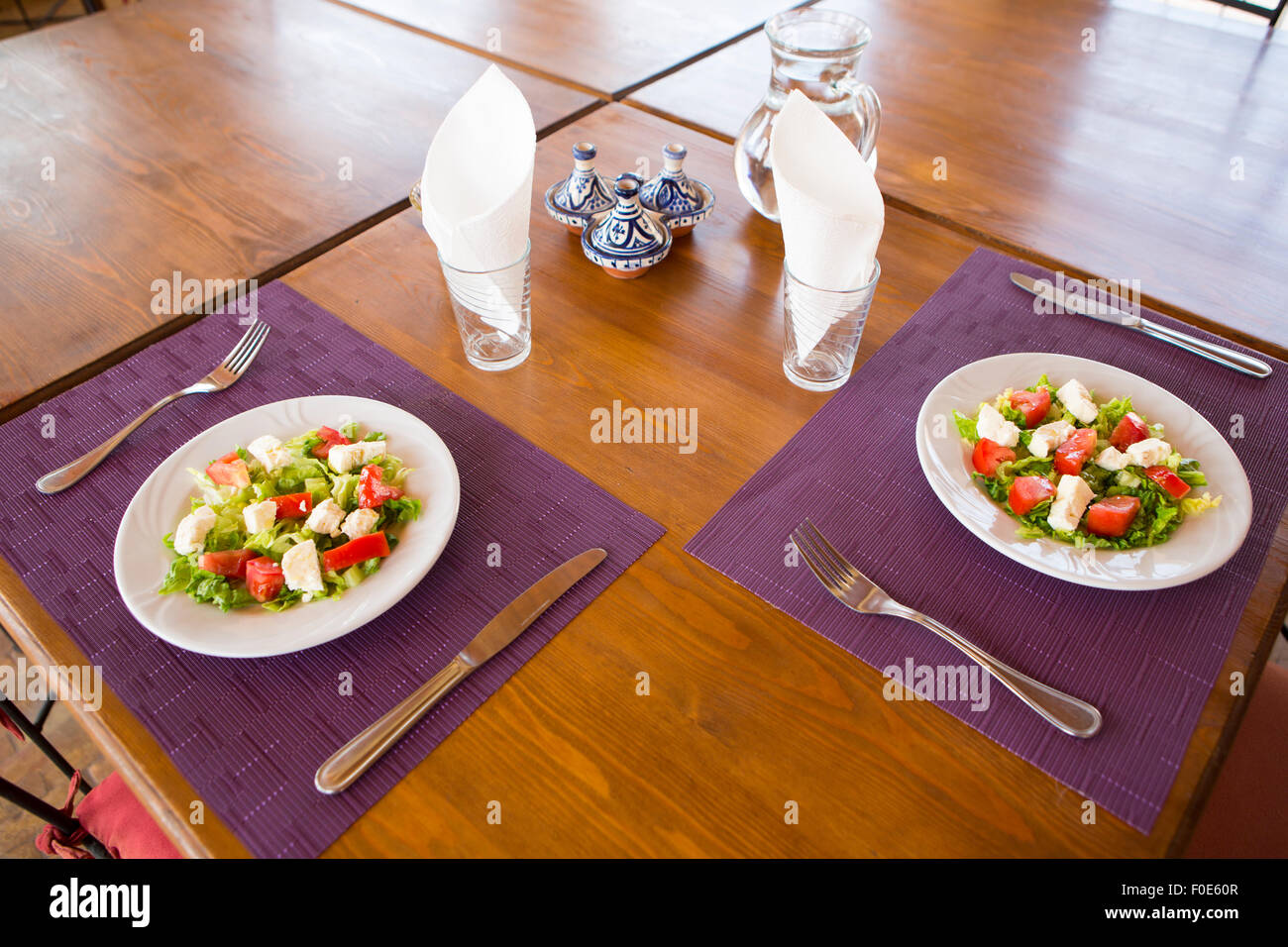 Nahaufnahme von einem leckeren marokkanischen grünen Salaten Platten mit Ziegenkäse und frischen Tomaten auf dem Tisch in Essaouira Restaurant serviert Stockfoto