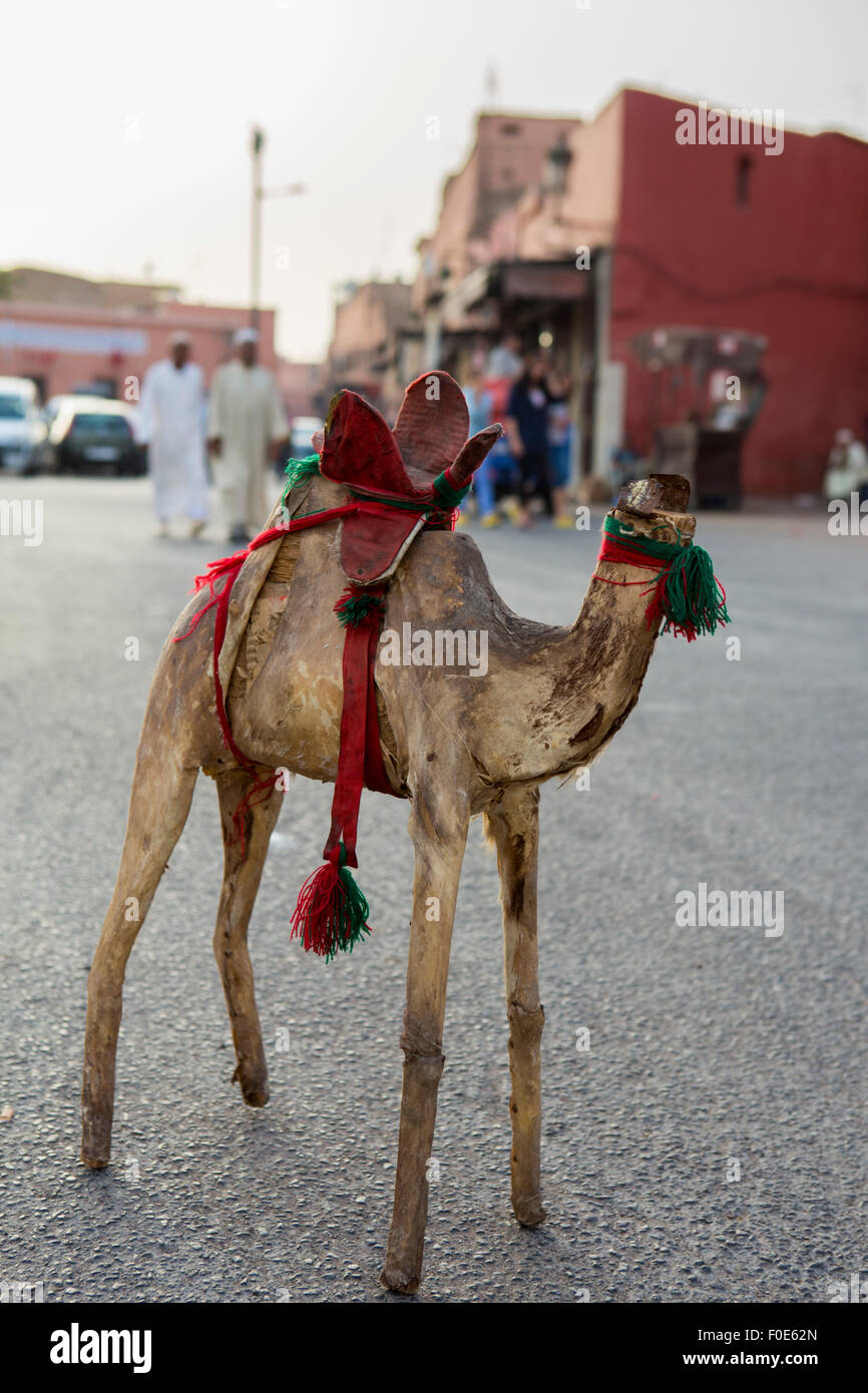 Kamel-Spielzeug mit gebrochenen Kopf auf dem freien Markt in Marrakesch Verlegung auf der Straße mit zwei islamische gekleidete Männer im Hintergrund Stockfoto