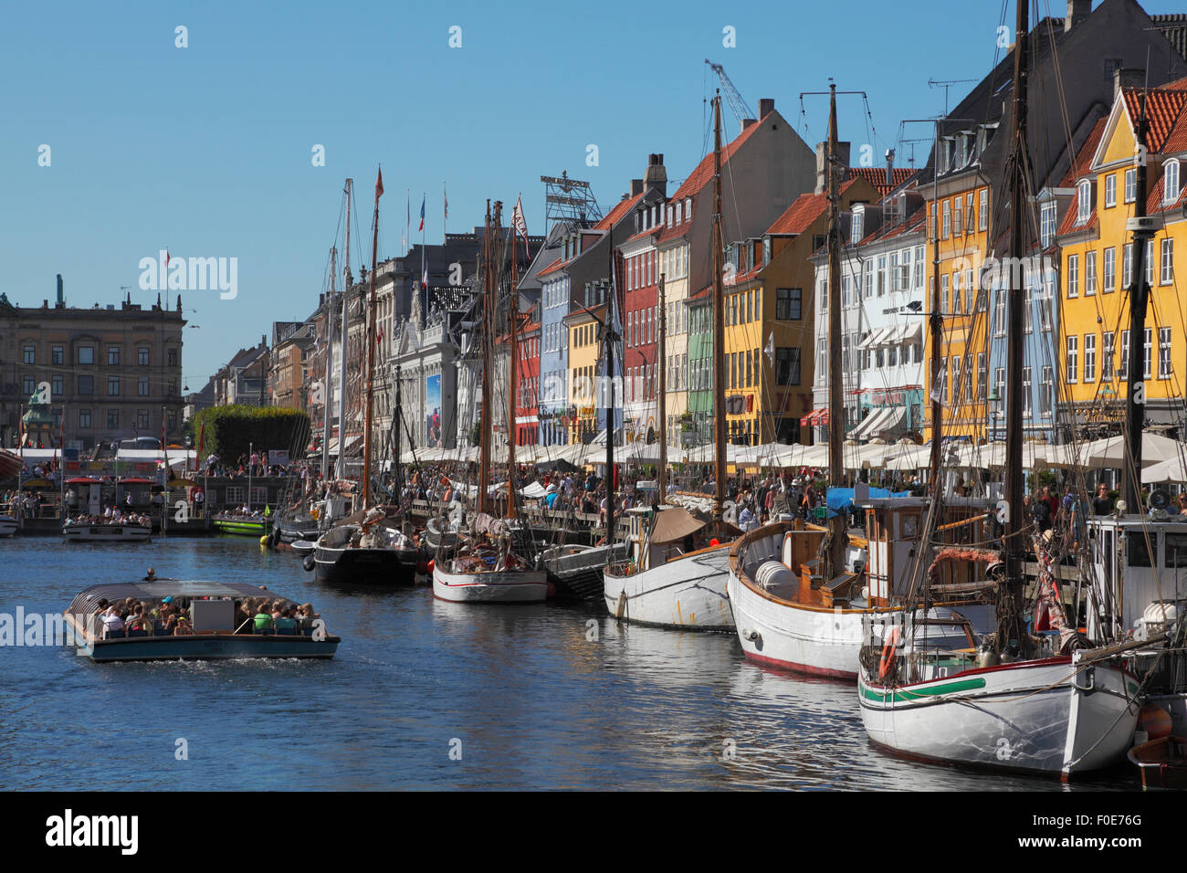 Nyhavn voll von alten Schiffen, überfüllten Kanal tour Boote und Leute an der Wasserseite und Pflaster Restaurants auf einer sehr hektischen Sommertag. Ambiente. Stockfoto