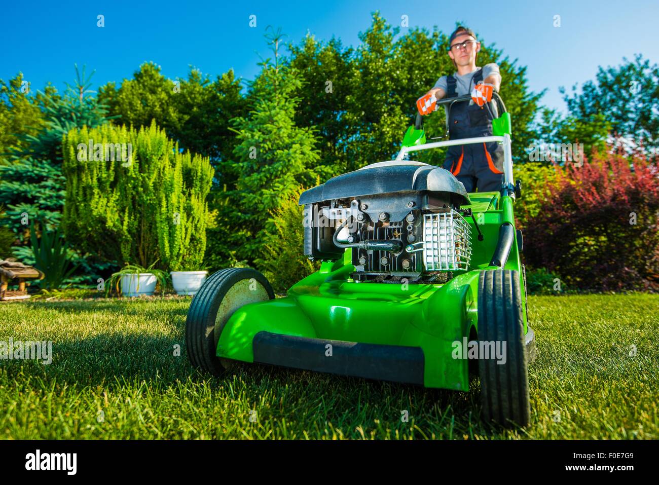 Landschafts-Geschäft. Gärtner Mähen Garten Rasen. Grüne Benzin-Rasenmäher Stockfoto
