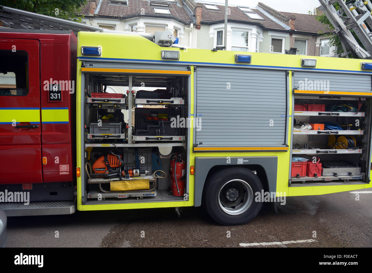 Feuerwehrauto auf einen Vorfall in einer Süd-West-Londoner Vorort zeigen die Fensterläden öffnen, um die Ausrüstung im Inneren offenbaren Stockfoto