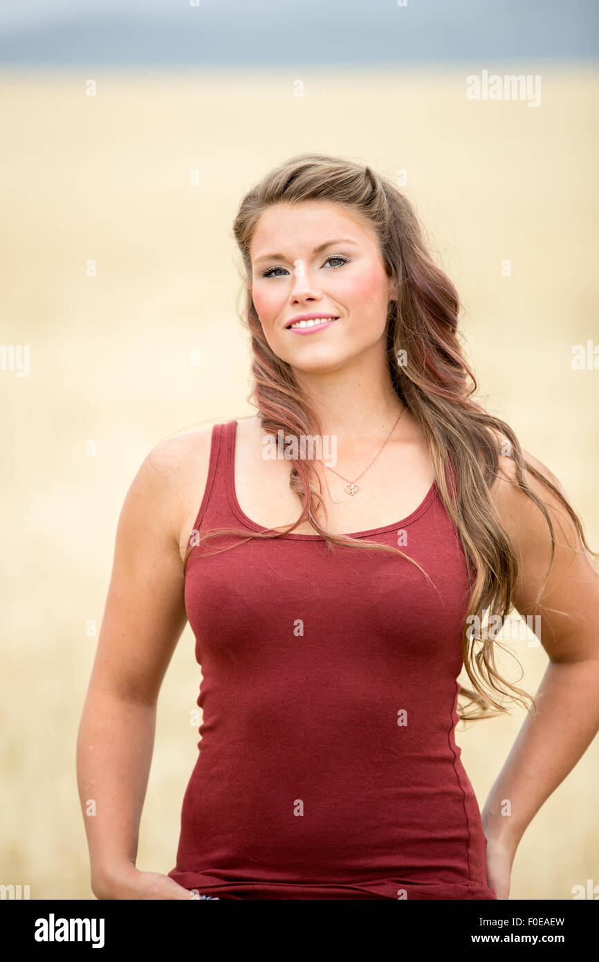 Junge Frau posiert in großen Weizen Feld tragen rote Tanktop. Stockfoto