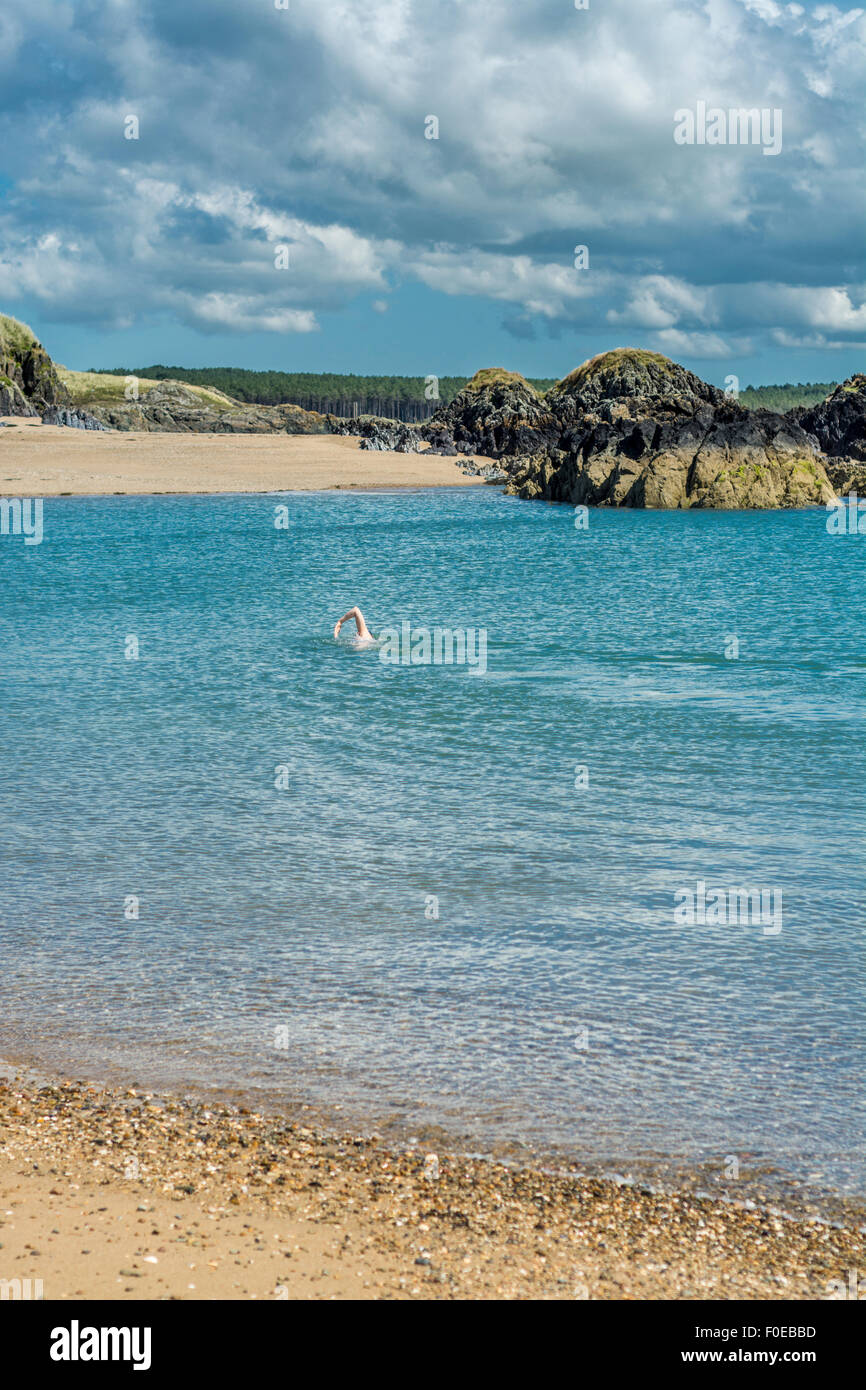 Schwimmer in der Lagune von Llanddwyn Island, Anglesey, North Wales, UK am 7. August 2015. Stockfoto