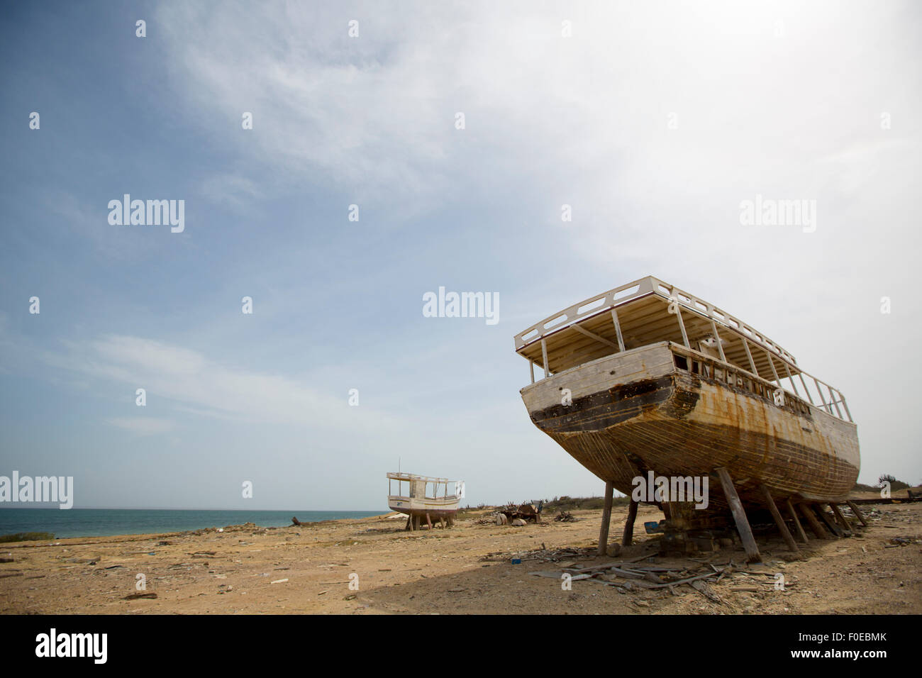 Am alten Schiffswrack stehen am Strand mit dem Meer im Hintergrund mit verblasste Bilder vor einem blauen Himmel. Insel Margarita Stockfoto