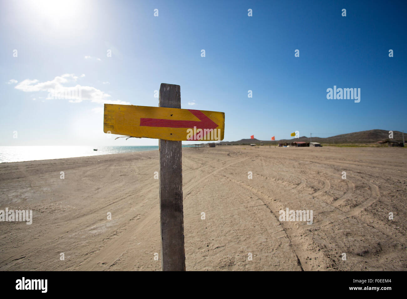 Holzschild mit einem Pfeil und der Strand im Hintergrund. El Cabo De La Vela, La Guajira, Kolumbien 2014. Stockfoto