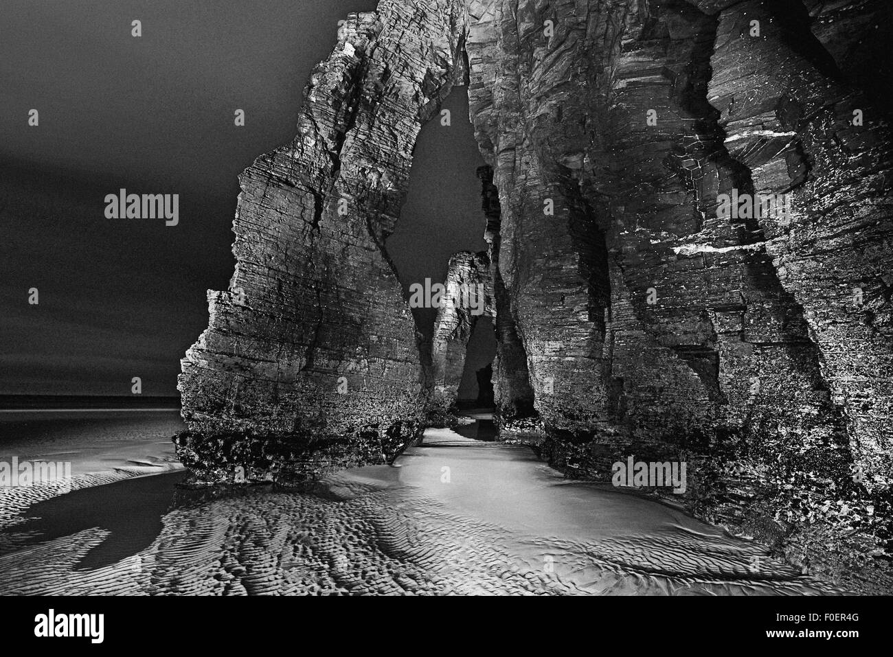 Spanien, Galicien: Felsbogen des Doms Strand bei Nacht als schwarz-weiß-version Stockfoto