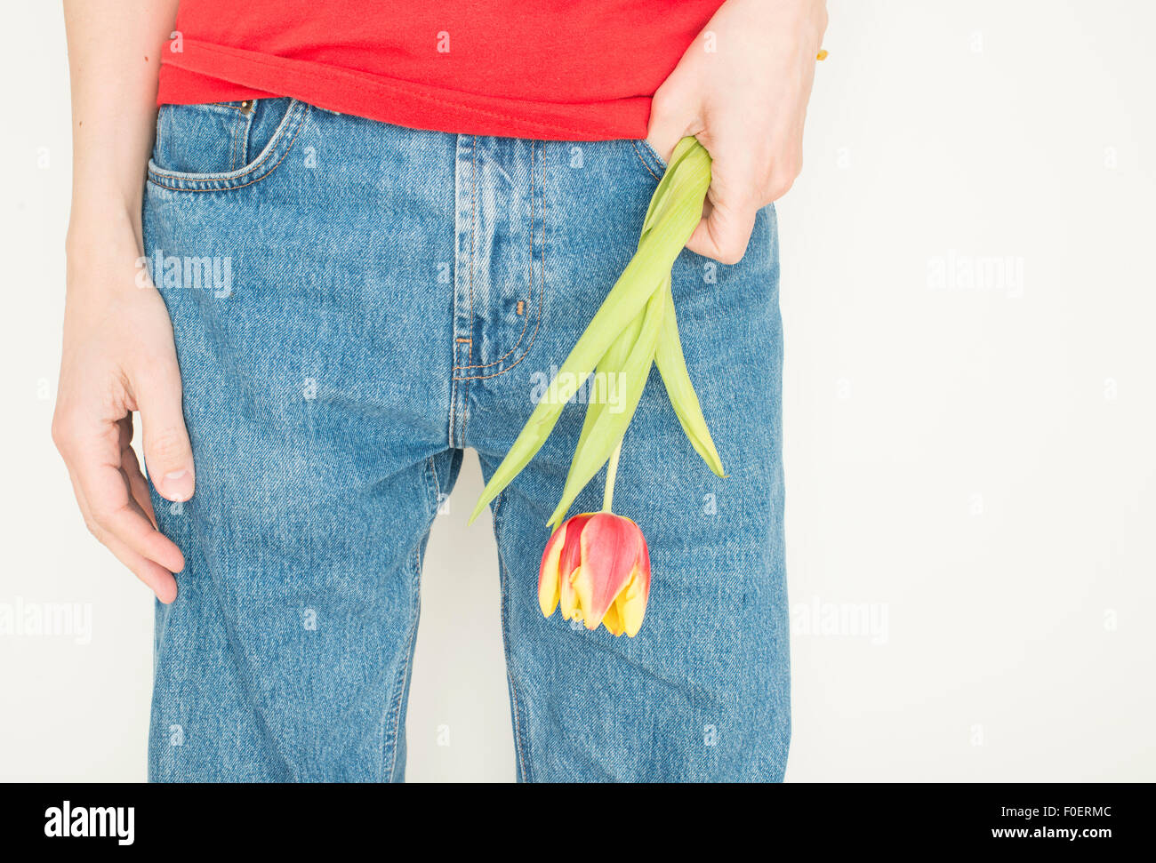Unsichere Mann hält eine Tulpe Blume Vorbereitung auf ein Datum. Stockfoto