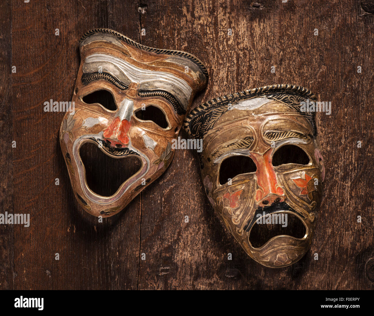 Komik und Tragik Masken auf hölzernen Hintergrund liegen. Still Life zeigt Emotionen durch den Kontrast von Freude und Trauer. Stockfoto