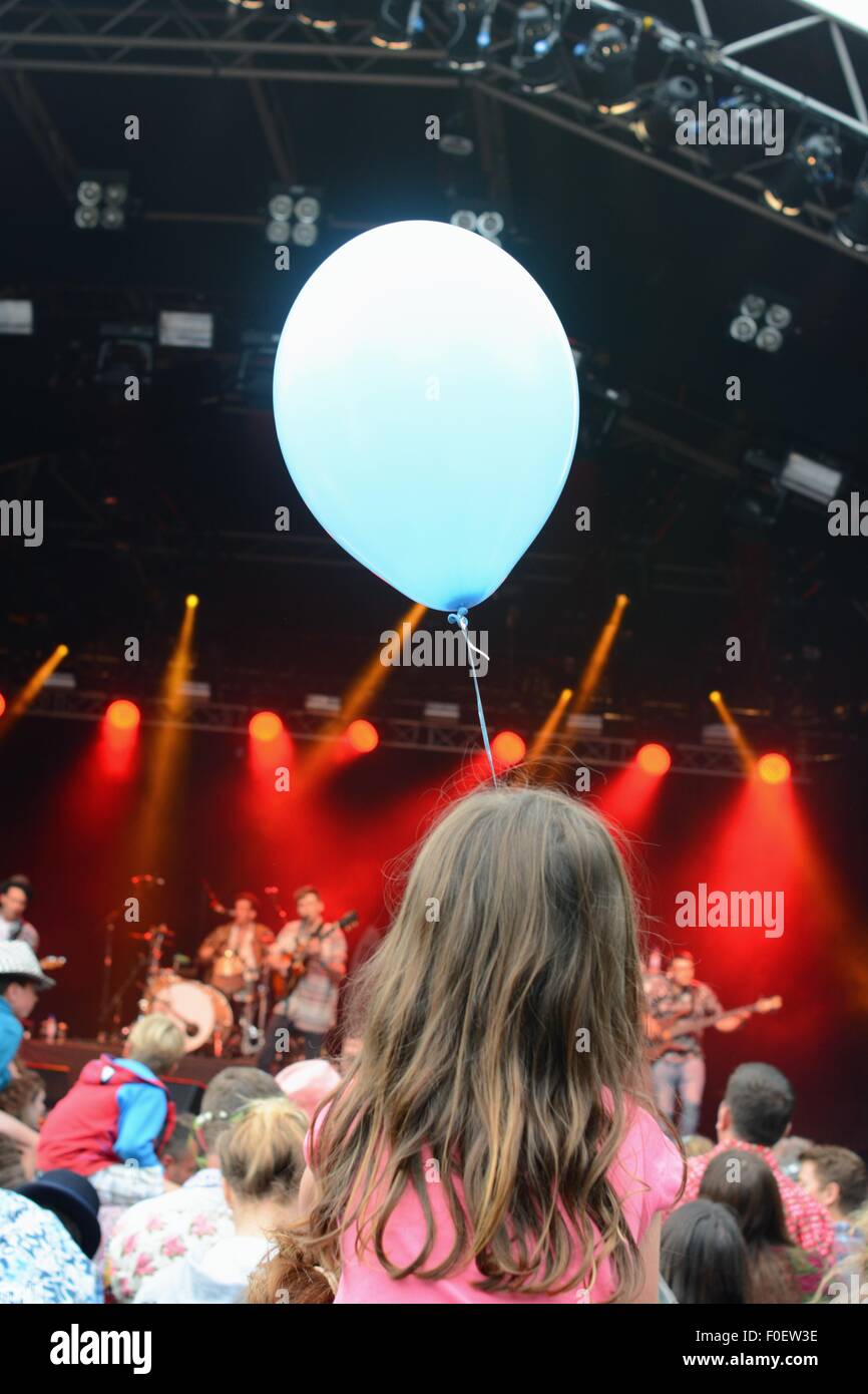 Das Mädchen mit dem blauen Ballon sitzen auf den Schultern zu einem Musikfestival Stockfoto