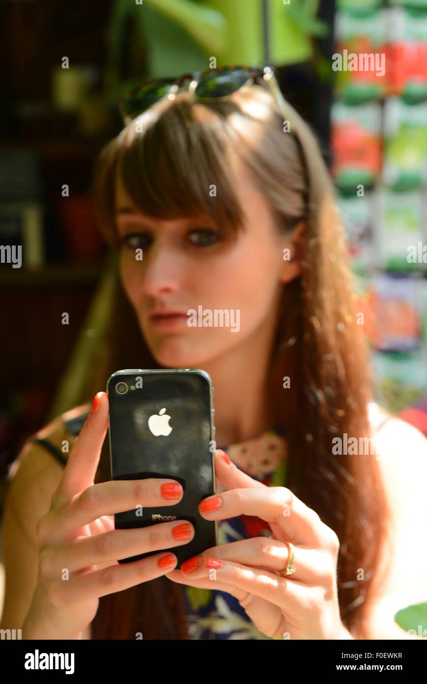 Attraktive junge Frau eine selfie mit einem iPhone Stockfoto