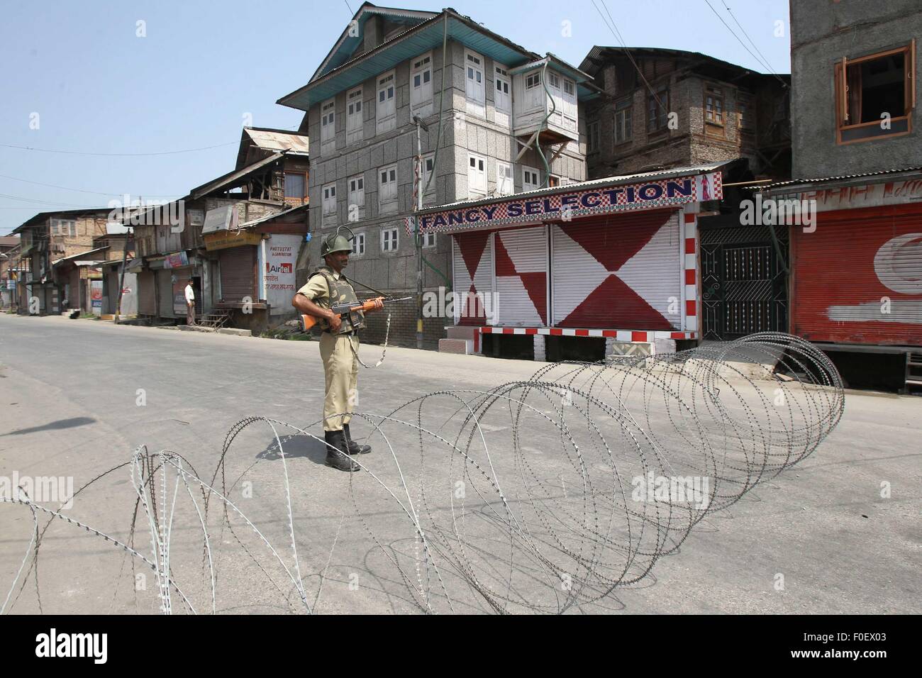 Srinagar, Kaschmir Indien kontrollierten. 14. August 2015. Eine indische paramilitärischer Soldat steht Wache in der Nähe von Stacheldraht während die Beschränkung in der Innenstadt von Srinagar, der Sommerhauptstadt von Indien kontrollierten Kaschmir, 14. August 2015. Behörden verhängt Ausgangssperre wie Einschränkung in vielen Teilen von Srinagar am Freitag Nachrichten berichtet. Bildnachweis: Javed Dar/Xinhua/Alamy Live-Nachrichten Stockfoto