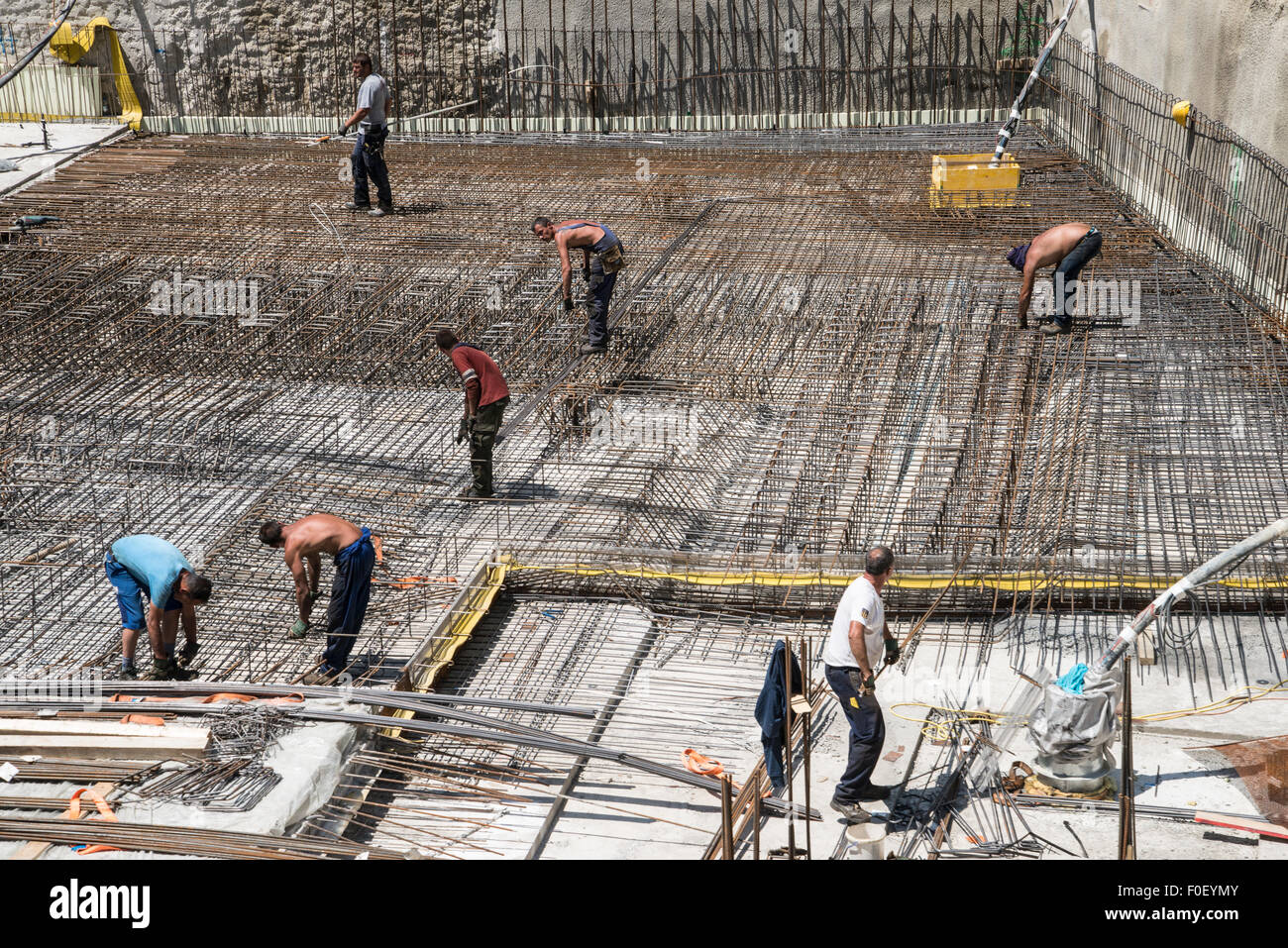 Keller bau Engineering mit einer Gruppe von Männern die Platzierung Stahl Betonstahl - Stangen vor konkreten gewälzt und platziert Stockfoto