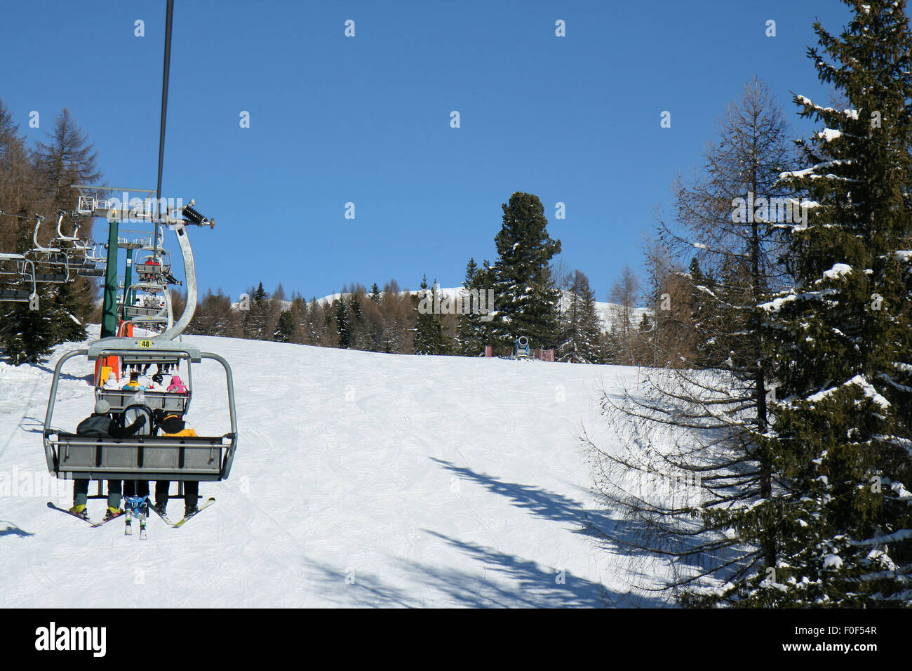 Skifahren in den Dolomiten, Skifahrer auf einem Sitzplatz auf der Piste. Val di Fiemme, Italien. Stockfoto