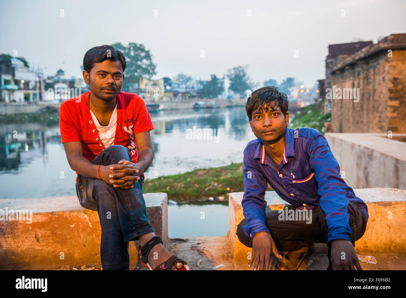 Zwei junge indische Männer entspannen auf einer Brücke über den Fluss Mandakini in Chitrakut, Madhya Pradesh, Indien Stockfoto
