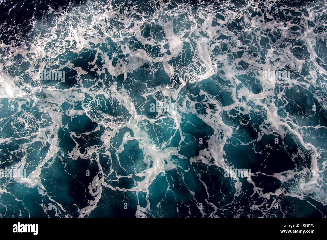 Blaue Meerwasser mit Schaum des Meeres als Hintergrund Stockfoto