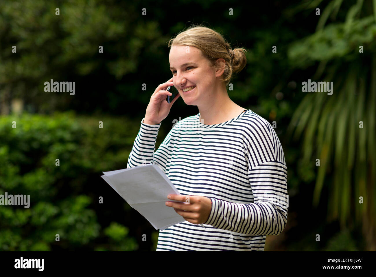 Eine blonde GCSE Studentin mit ihren Prüfungsergebnissen zufrieden. Stockfoto