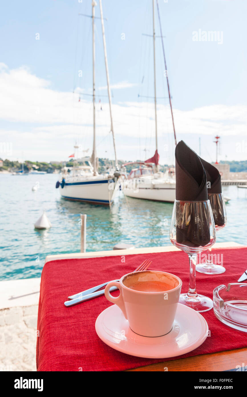 Tasse Kaffee am Tisch im Restaurant am Wasser neben dem Hafen in Villefranche-Sur-Mer an der Côte d ' Azur, Frankreich. Stockfoto