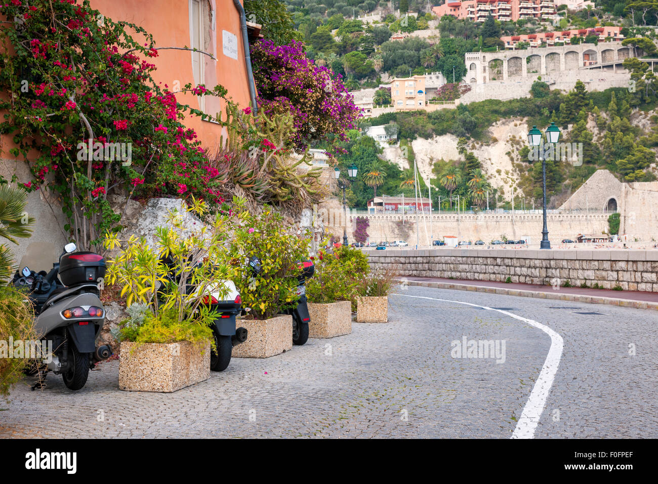 Waterfront Straße geparkten Rollern mit blühenden Bougainvillea im Altstadt Villefranche-Sur-Mer an der Côte d ' Azur, Frankreich. Stockfoto