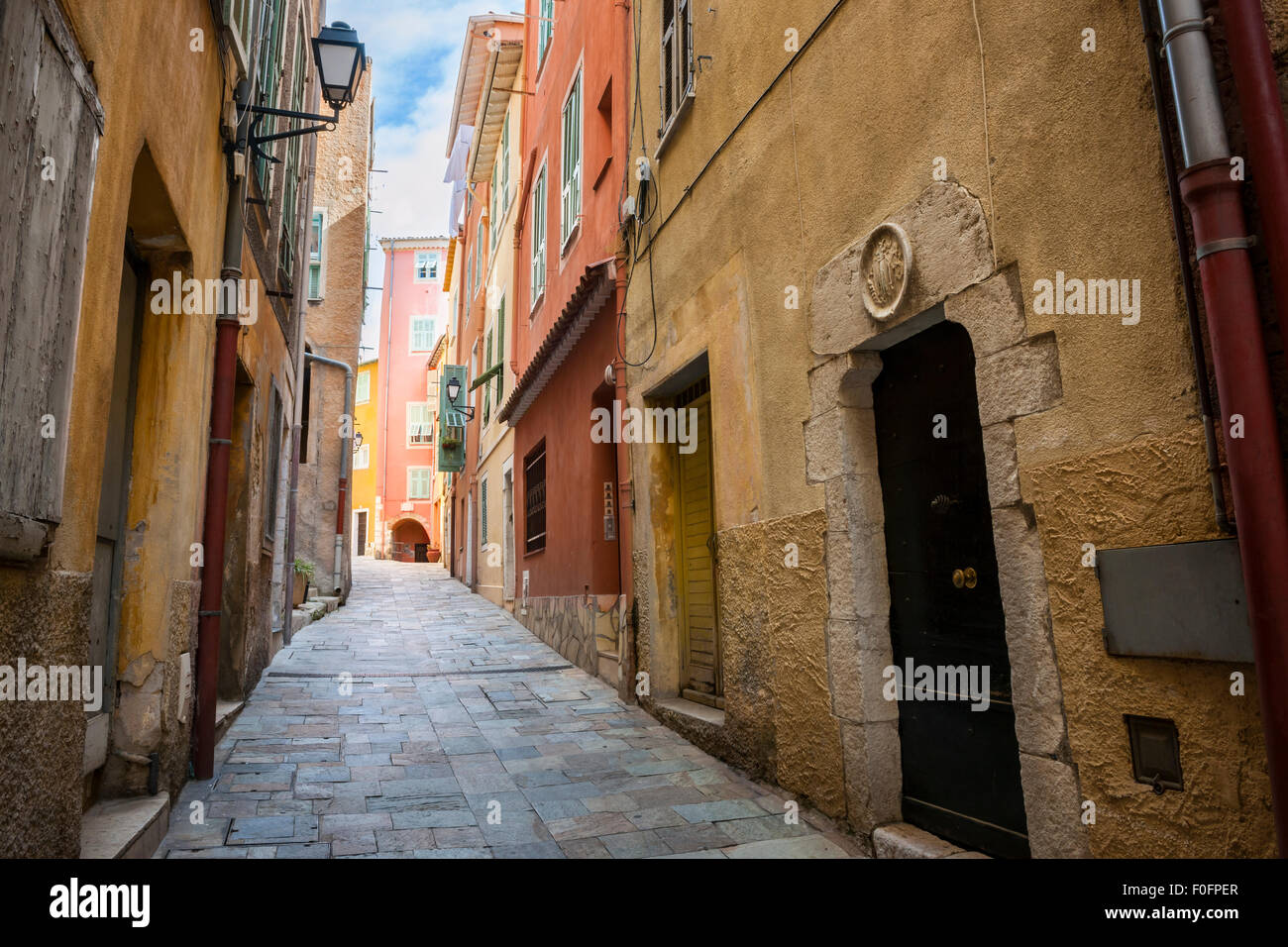 Schmale gepflasterte Straße in der mittelalterlichen Stadt Villefranche-Sur-Mer an der Côte d ' Azur, Frankreich. Stockfoto
