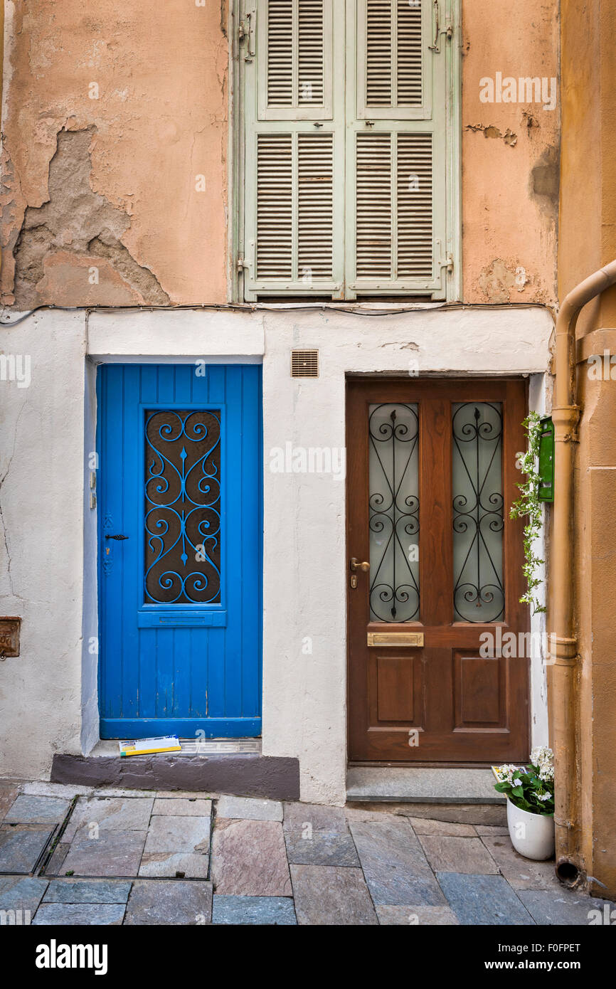 Zwei Türen und Fenster mit Fensterläden auf alten Haus in Villefranche-Sur-Mer, Frankreich. Stockfoto
