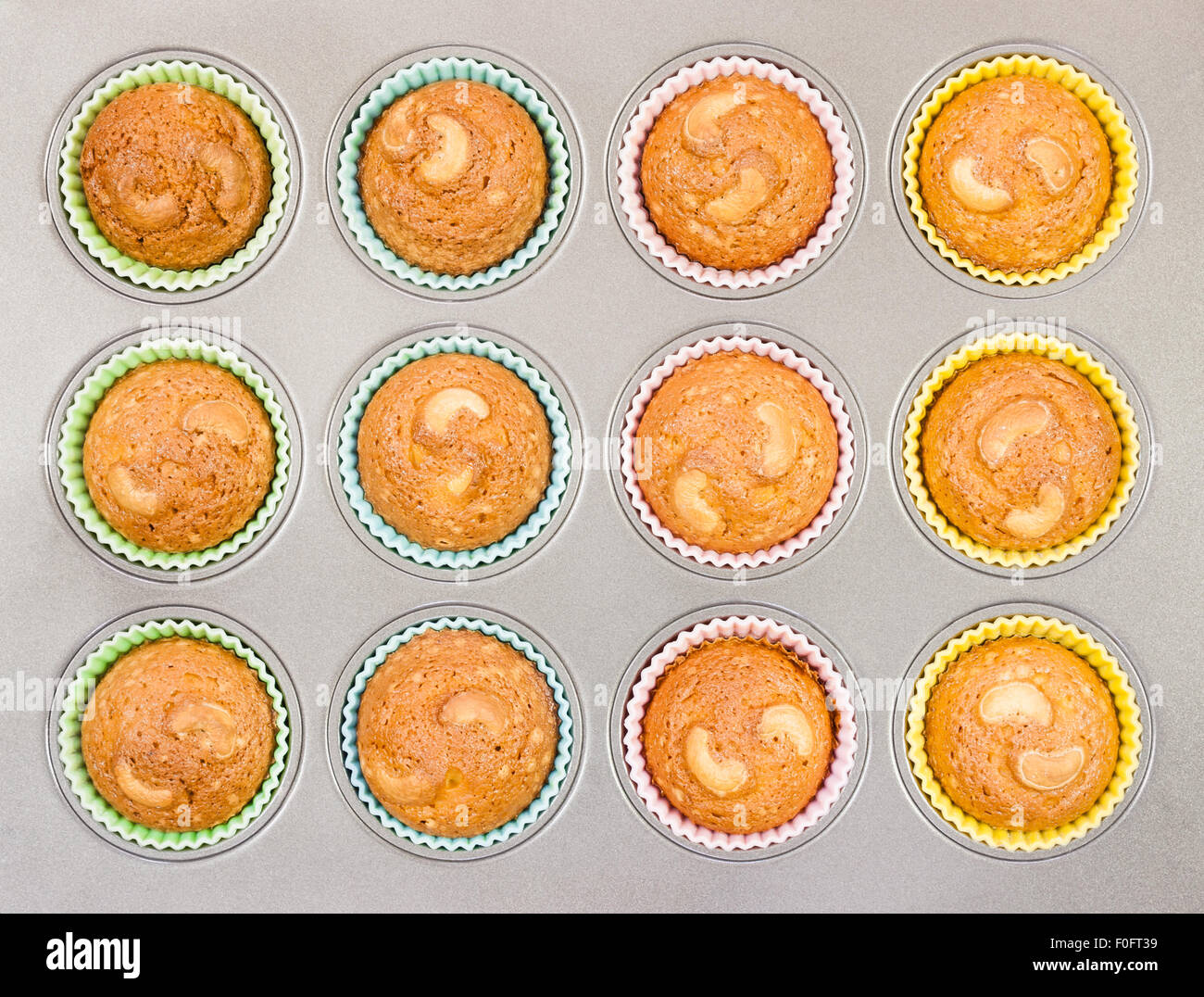 Eine Draufsicht des köstlichen golden braun verkrustet Cashew-Cupcakes gebacken in einer Schale mit Silikon Cups. Stockfoto