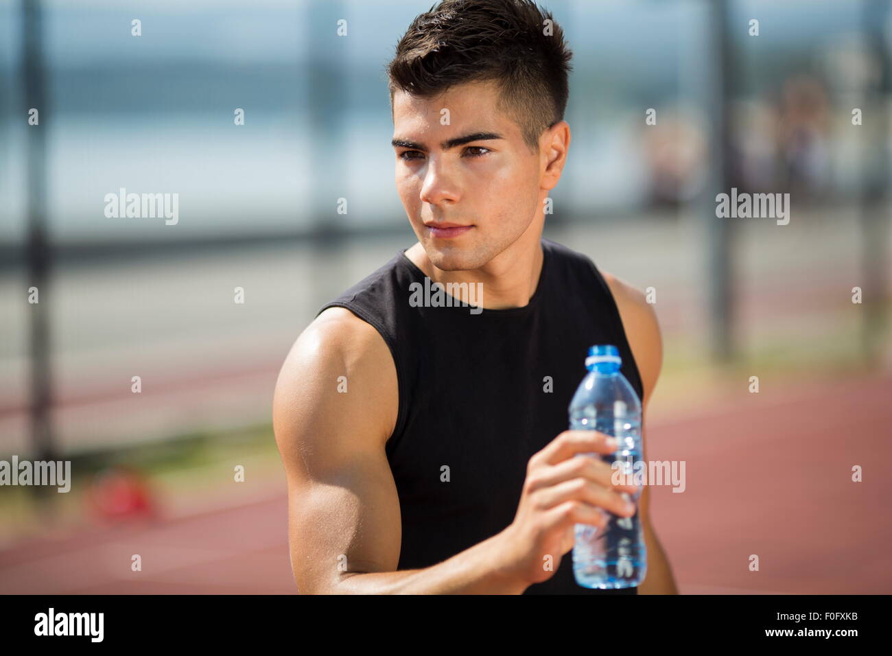 Junger Mann Trinkwasser im Sommer Stockfoto