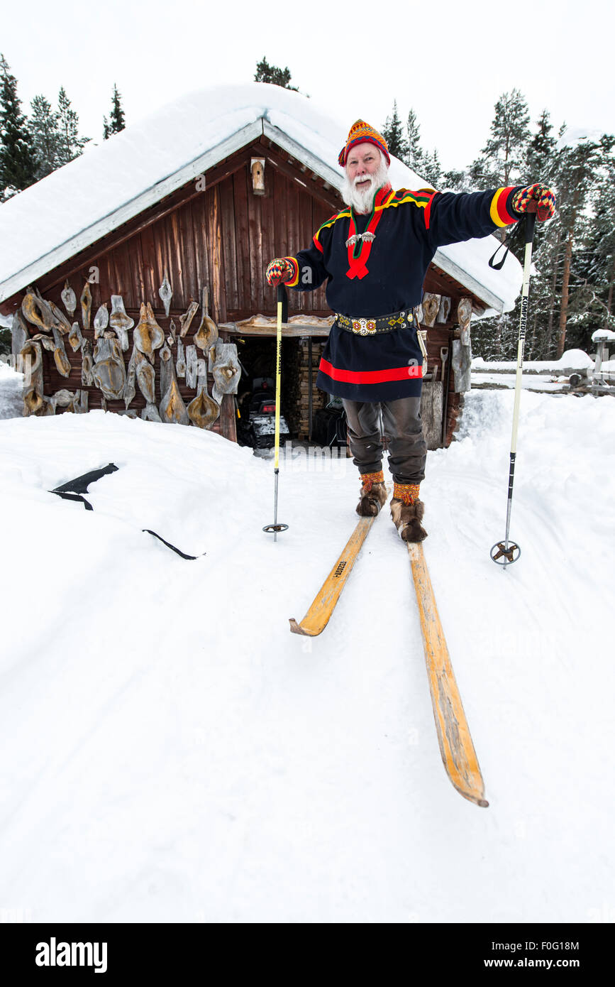 Sami Männchen auf Skiern mit Sami Haus im Hintergrund schwedischen Lappland Schweden Skandinavien Stockfoto