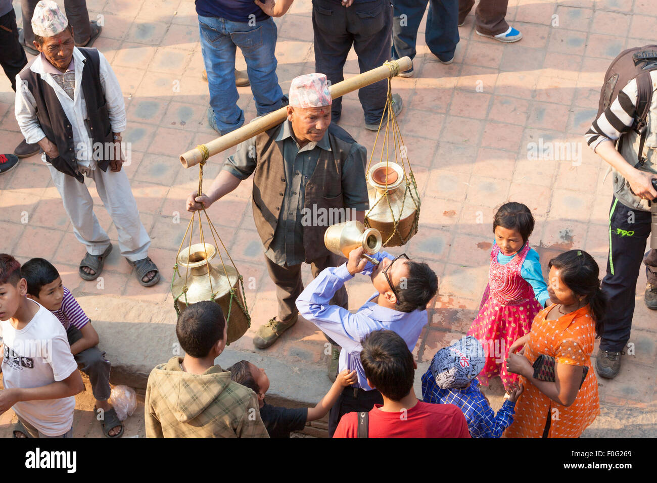 Junge Nepalesen Heiligen Trinkwasser während der Festlichkeiten des nepalesischen Neujahrs in Bhaktapur, Nepal Stockfoto