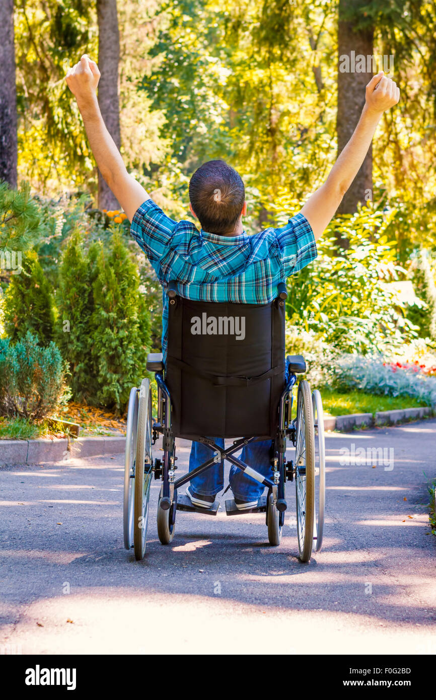 junger Mann im Rollstuhl mit weit geöffneten Armen, sein Leben zu genießen Stockfoto