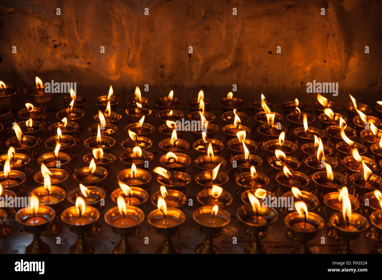 Dharamsala Himachal Pradesh, Indien. Reihen von brennen Butterlampen im buddhistischen Tempel im Norbulingka Institut. Stockfoto