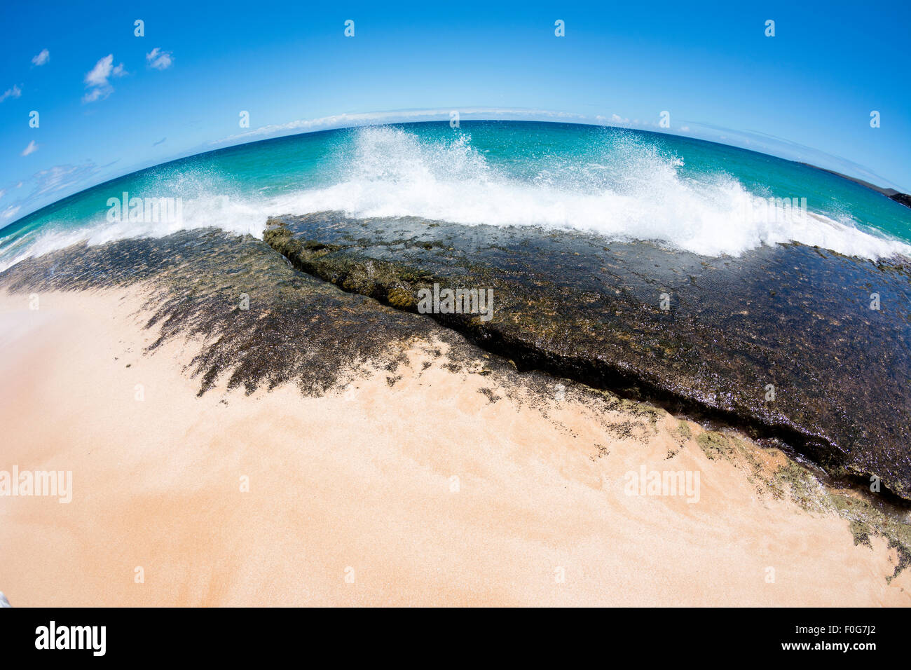 Nahaufnahme von einem Riff an der Küste von einem tropischen Sandstrand mit Surf Absturz in das Riff Stockfoto