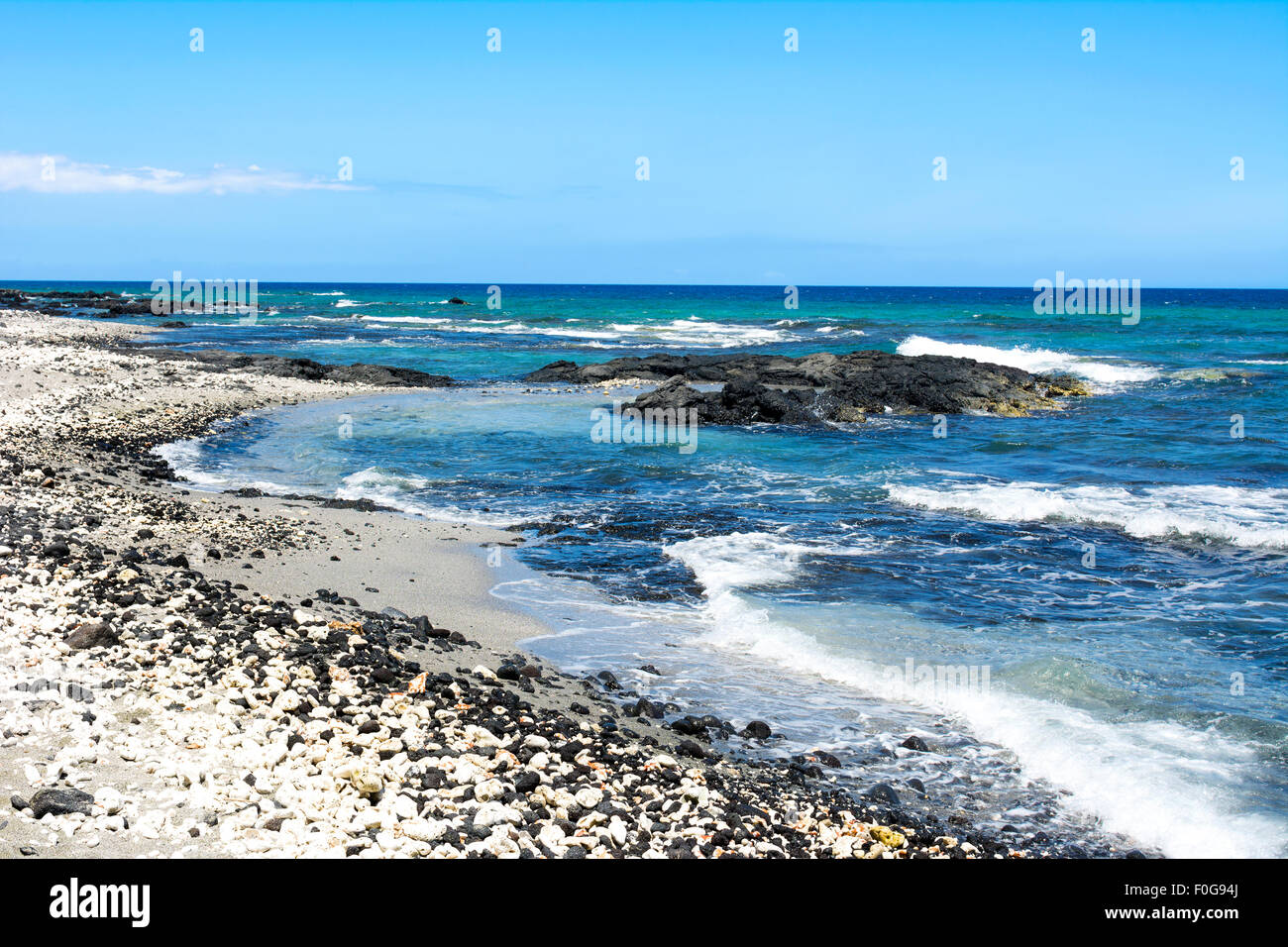 Eine schöne schwarze und weiße Kiesstrand mit klaren, blauen Wasser an einem einsamen Strand in Kona Hawaii. Stockfoto