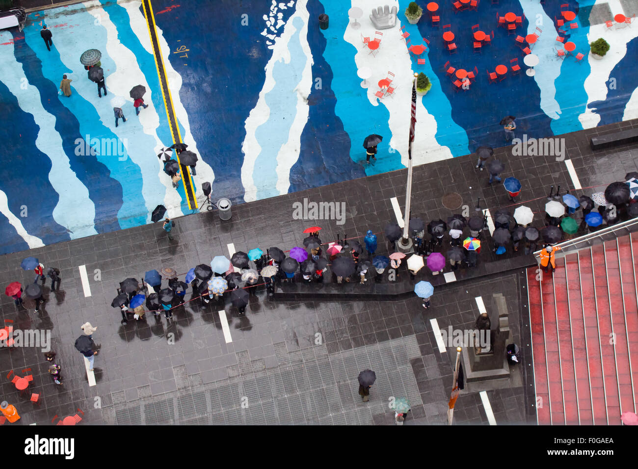 Luftaufnahme des Times Square in New York City an einem regnerischen Tag. Viele Menschen sind mit Sonnenschirmen, die einen bunten Überblick über Fräsen Stockfoto