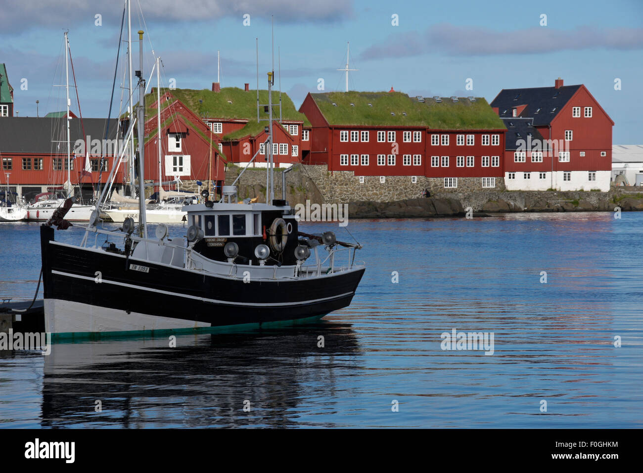 Rasen-roofed Gebäude auf Tinganes Halbinsel und Fischerboote im Westhafen, Tórshavn, Stremoy Island, Färöer Inseln Stockfoto