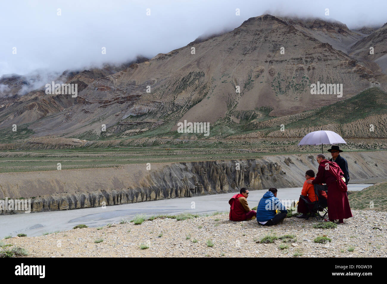 Buddhistische Mönche entspannend im Himalaya Gebirge in der Nähe von gefrorenen Himalaya Fluss in Leh Ladakh Indien Stockfoto