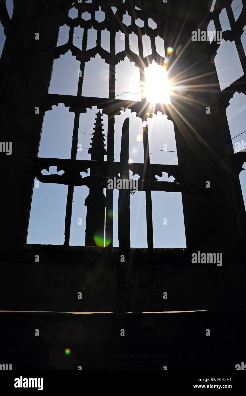 Silhouetted Bogenfenster mit der Sonne, reißt in den Ruinen der alten Kathedrale, Coventry, West Midlands, England. Stockfoto