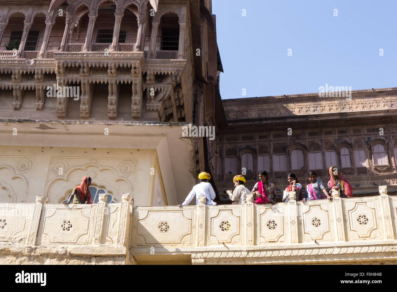 Jodhpur, Indien. Mehrangarh Fort; Indische Besucher in hellen bunten Kleid auf einem Balkon Stockfoto