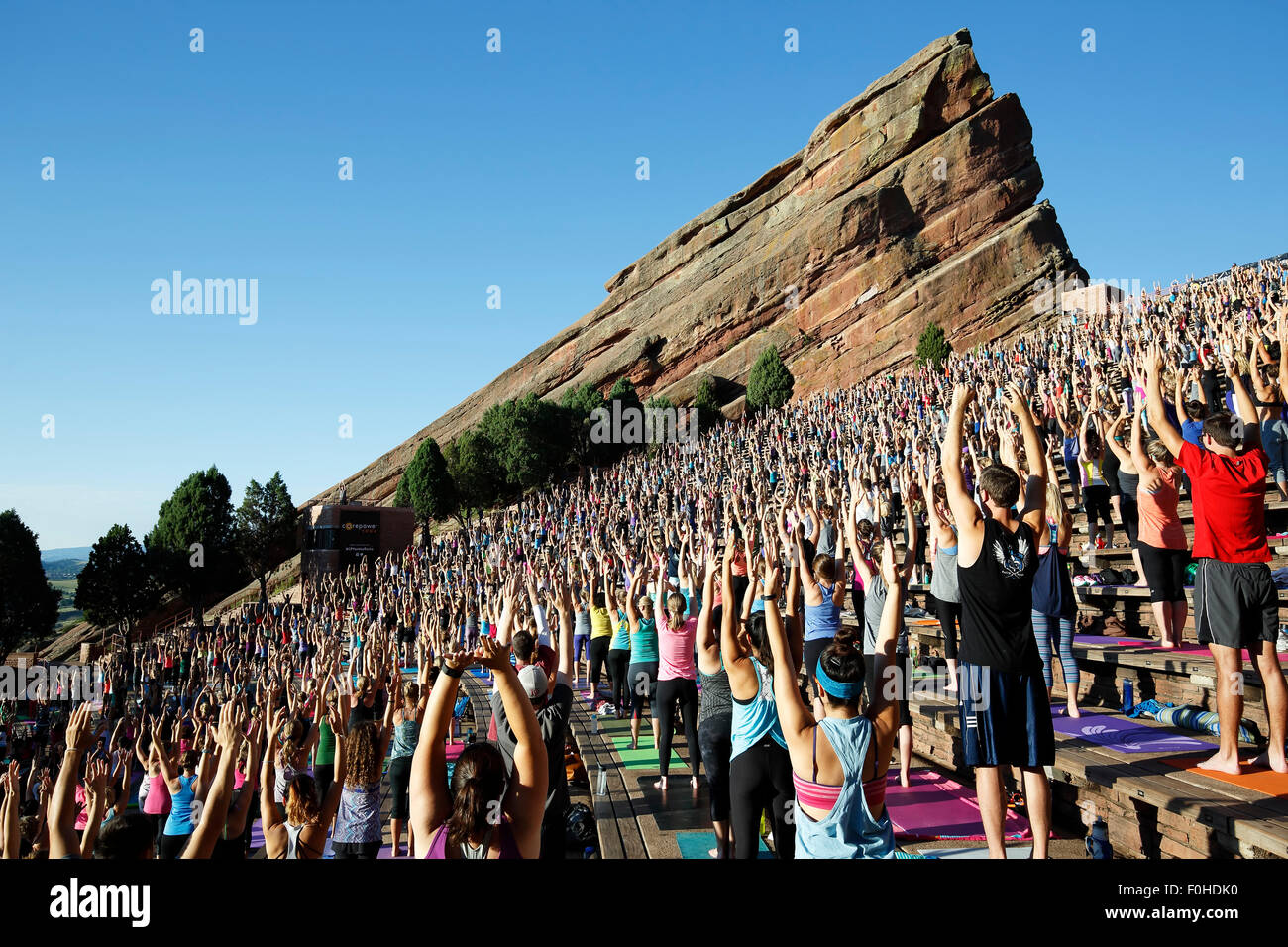 Praktizierende, Yoga auf den Felsen, Red Rocks Amphitheater, Morrison, Colorado USA Stockfoto